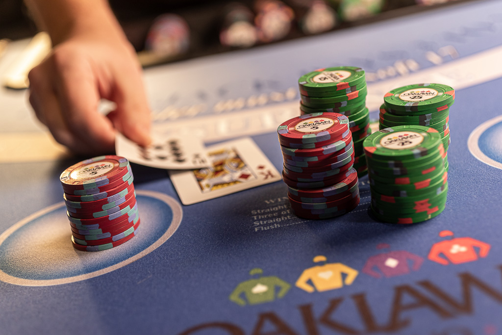 Stacks of Oaklawn casino chips on a poker table as the dealer reveals his hand
