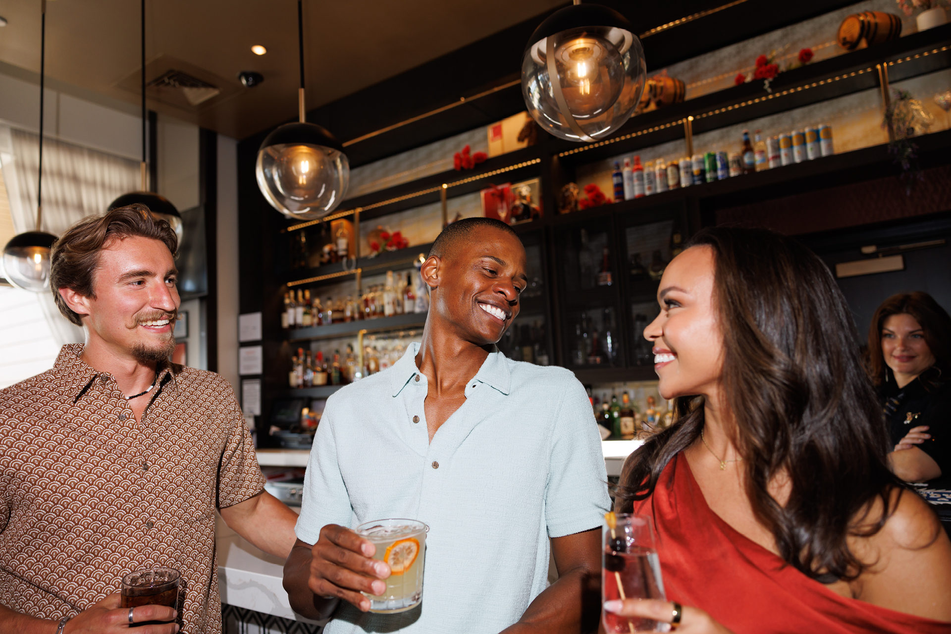 An elegantly dressed group of friends has cocktails at Oaklawn's First Turn Bar.